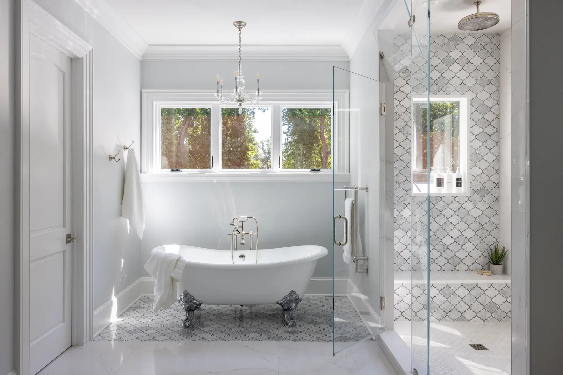 The primary bath: a clawfoot soaking tub, marble floors and a glass shower.