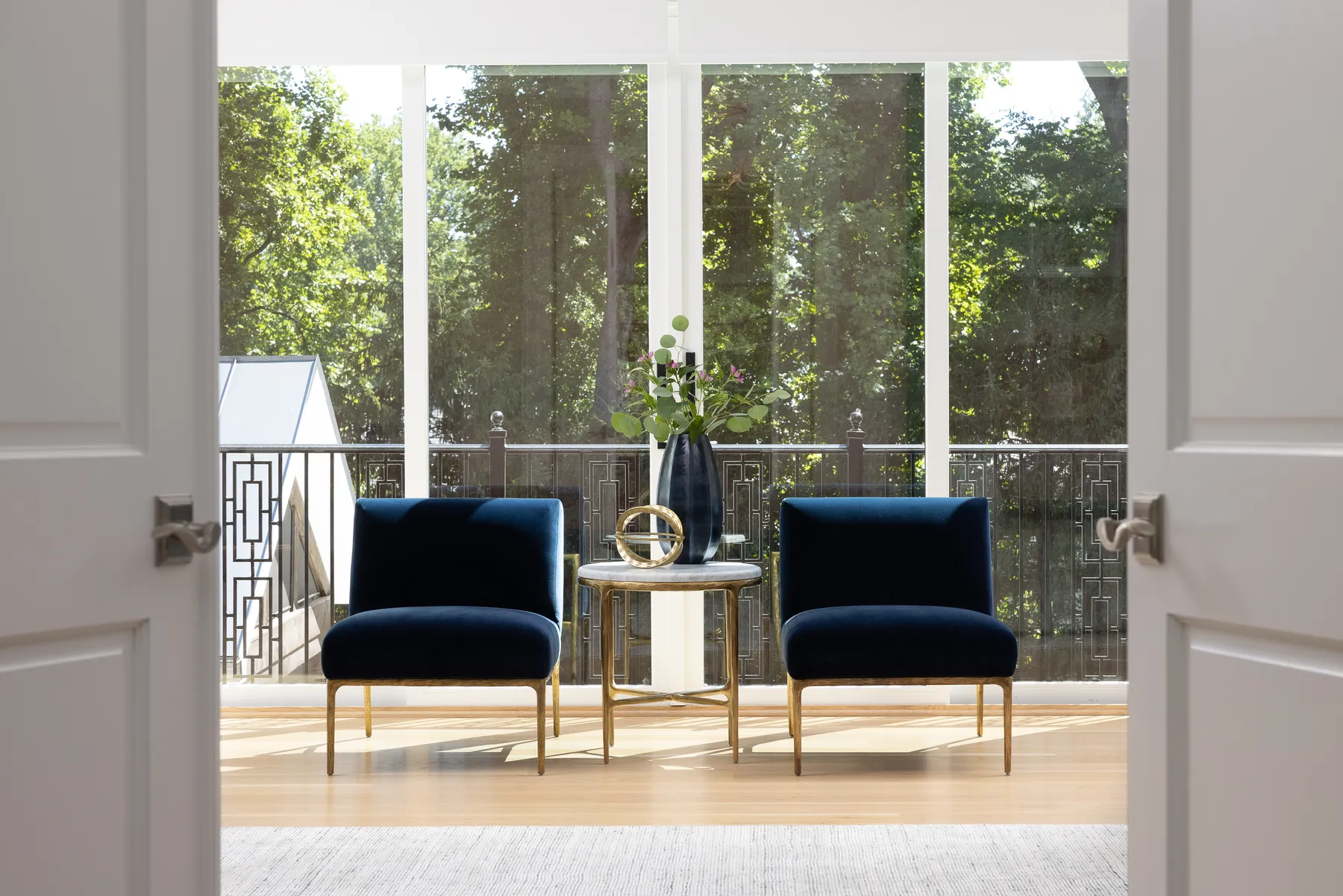 The sitting area looks out to the trees through floor to ceiling windows.