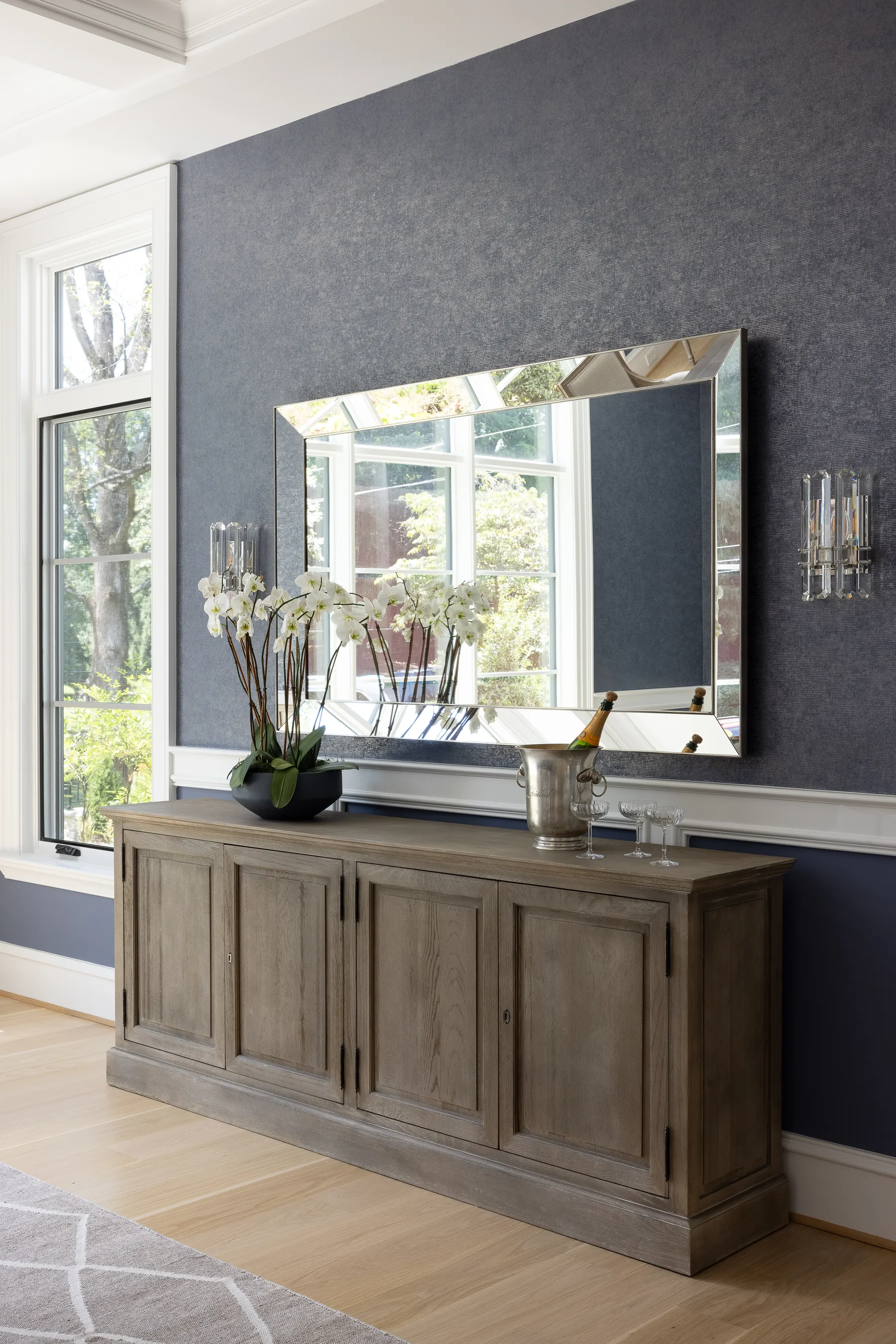 A reclaimed wood console and a beveled mirror in the dining room.
