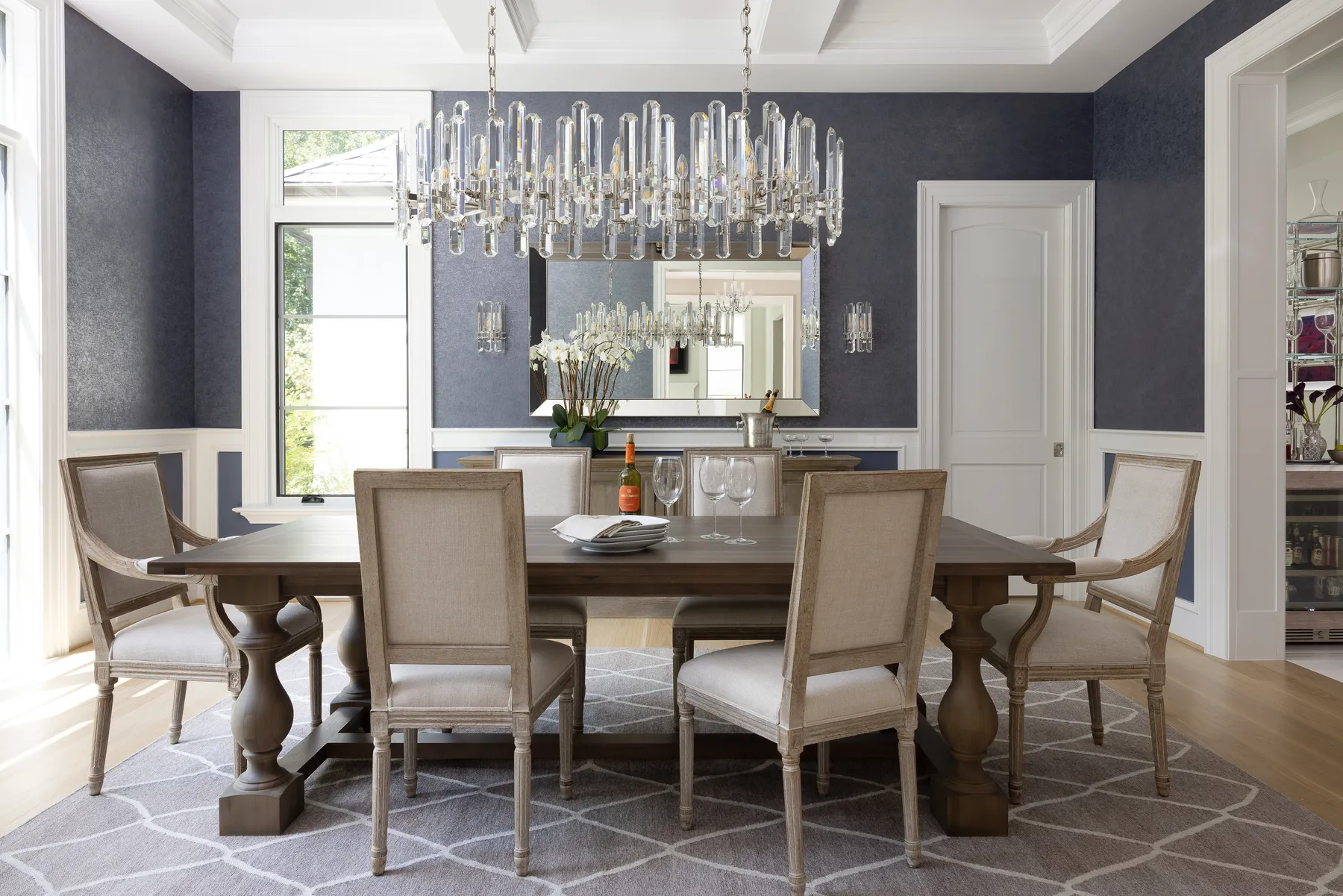 The dining room: stormy blue iridescent wallpaper and a crystal chandelier.