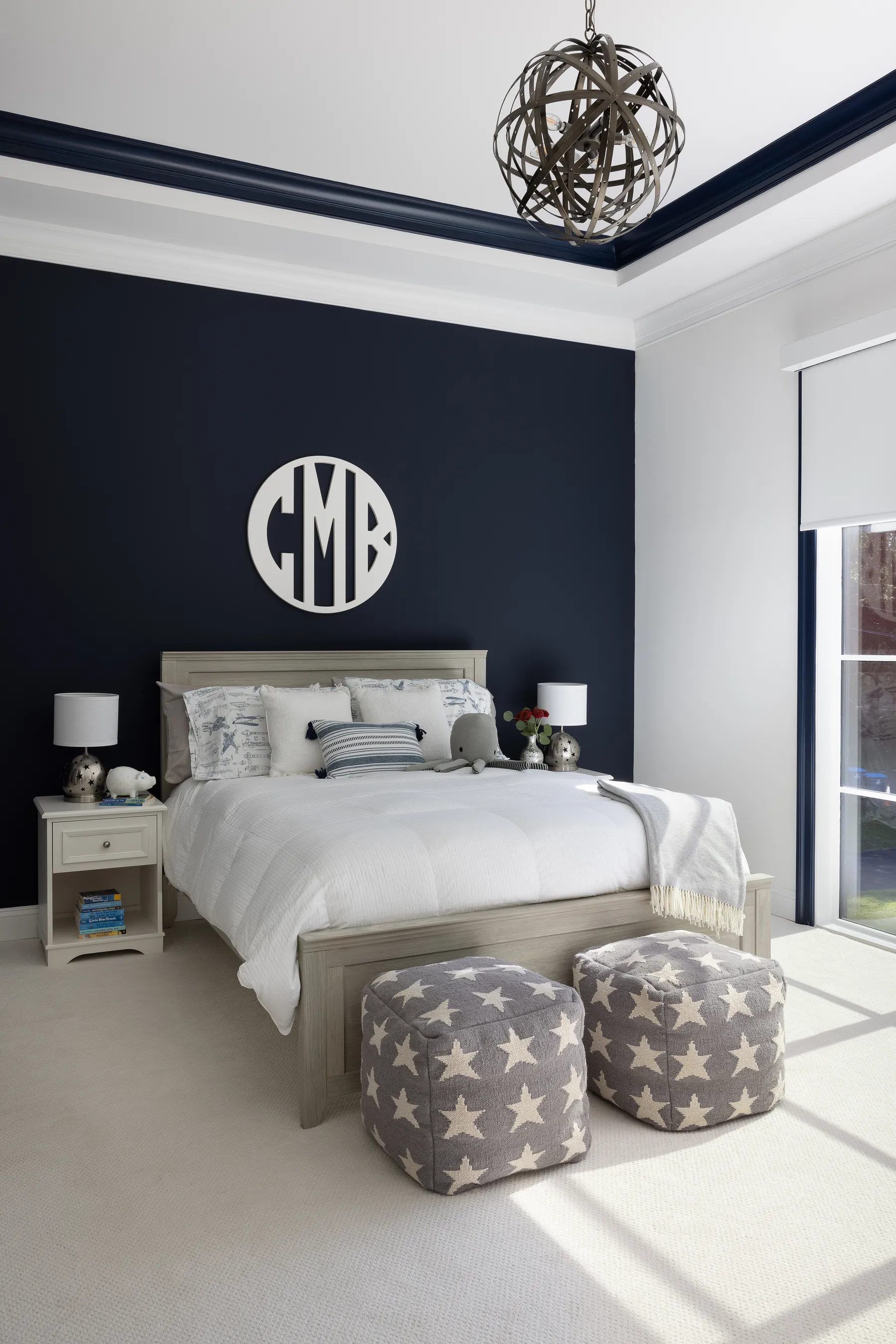 Their son's room in deep navy with a monogram over the bed.