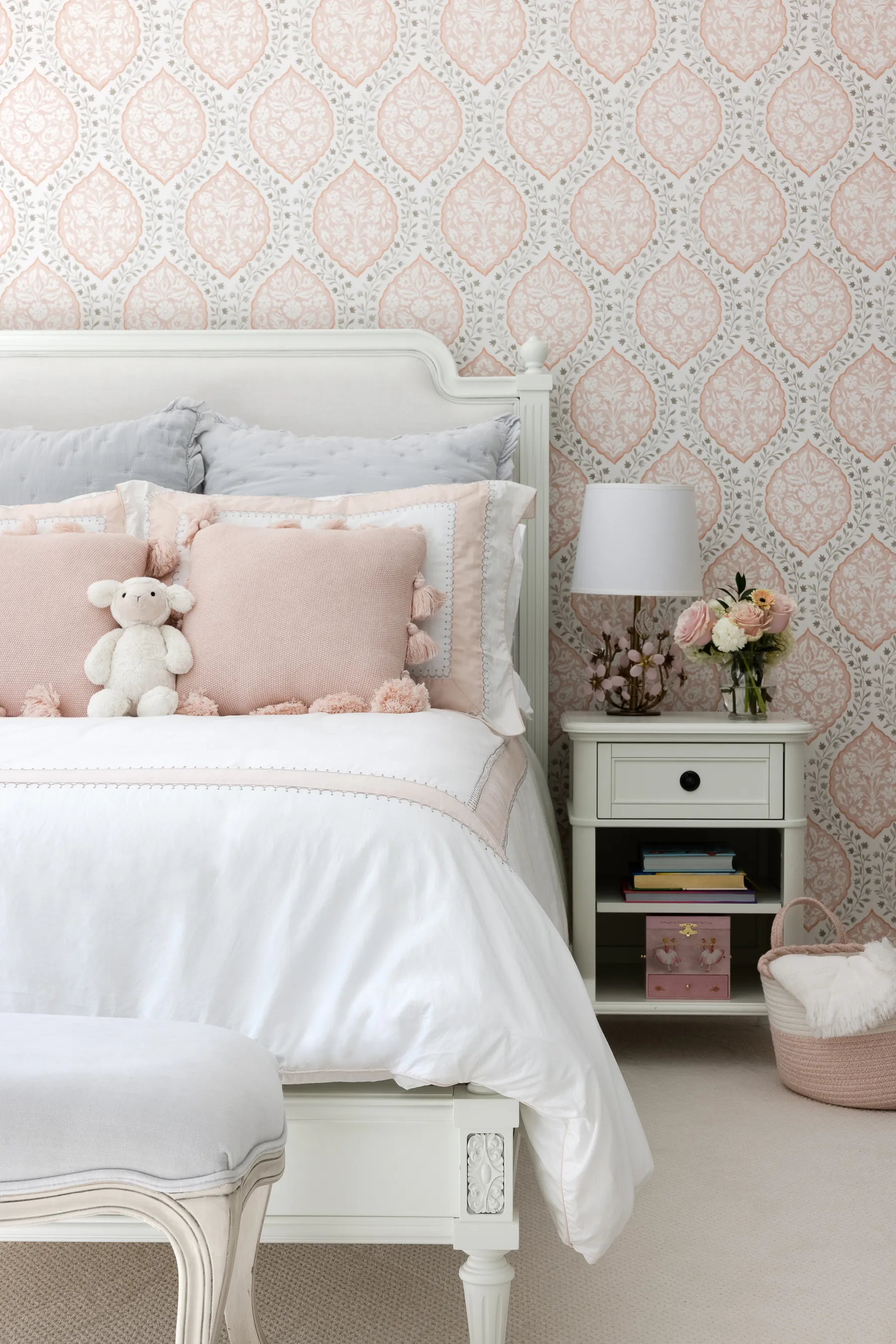 Their daughter's room: floral wallpaper, pink bedding and a painted bed.