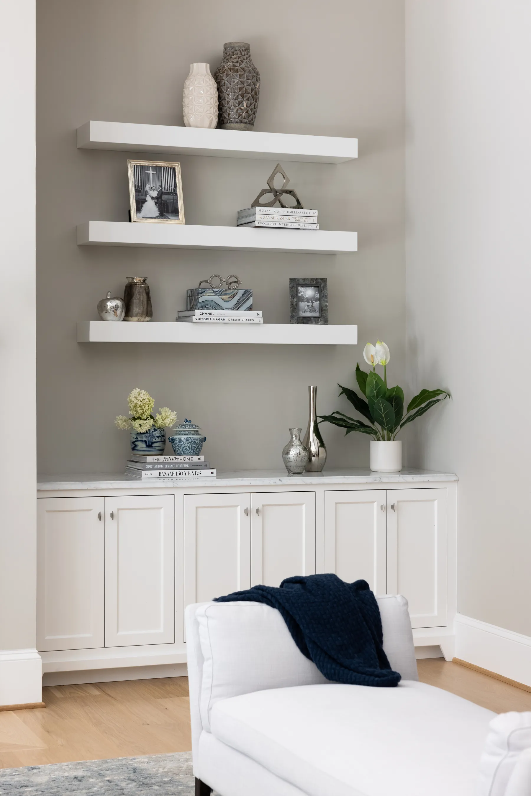 Floating shelves styled with family photos, blue and white porcelain and silver.