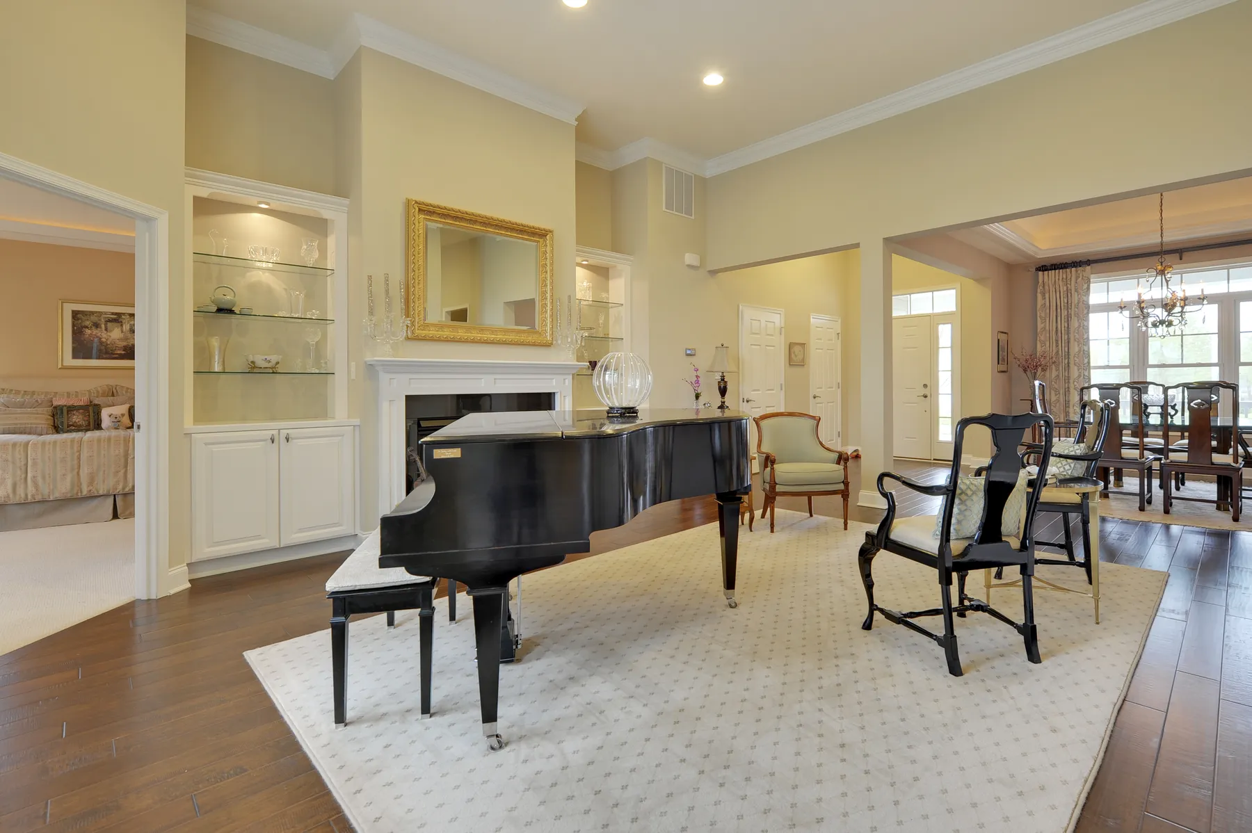A music room with a grand piano and gold-framed art.