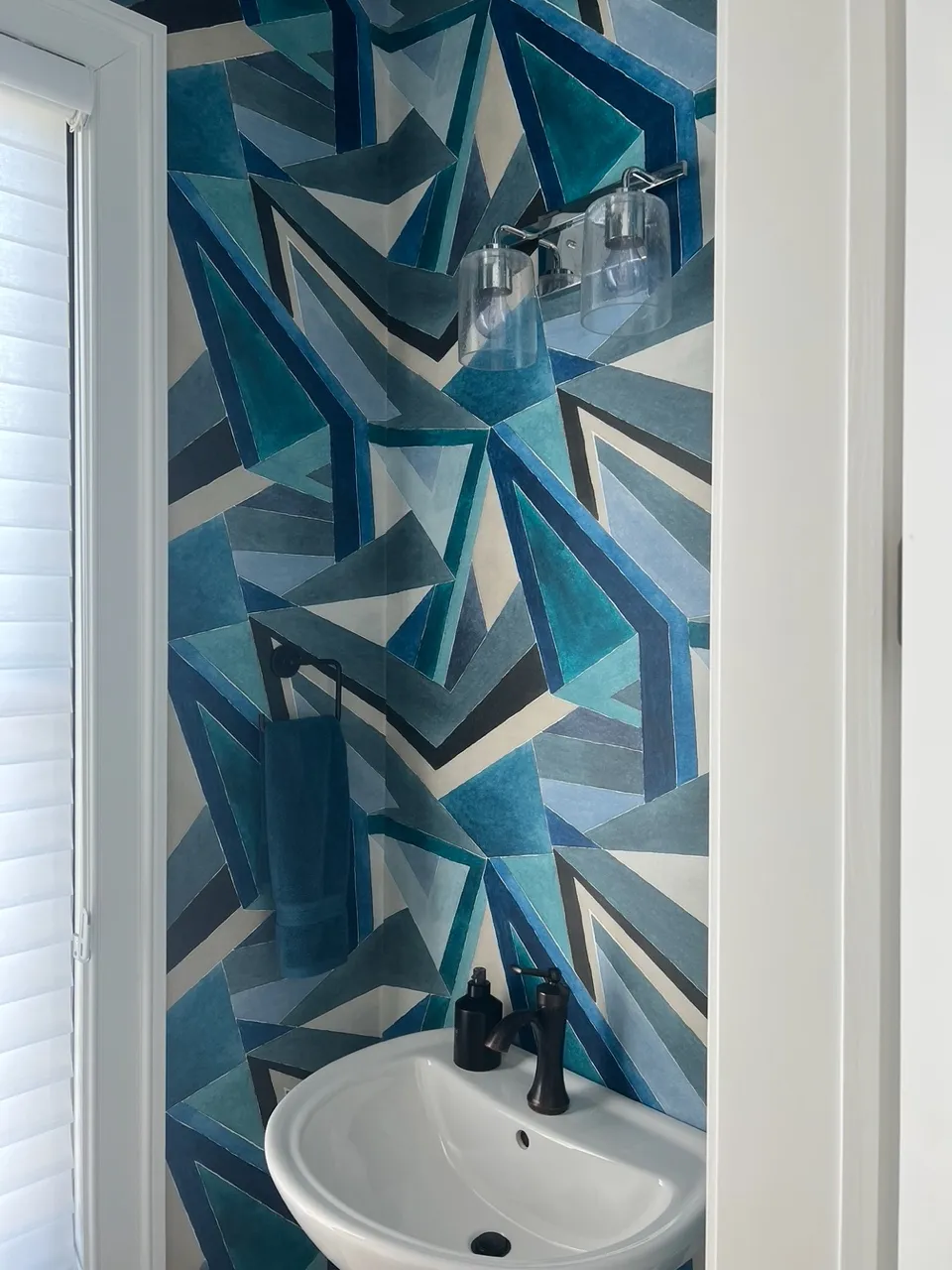 A powder room in blue geometric wallpaper.