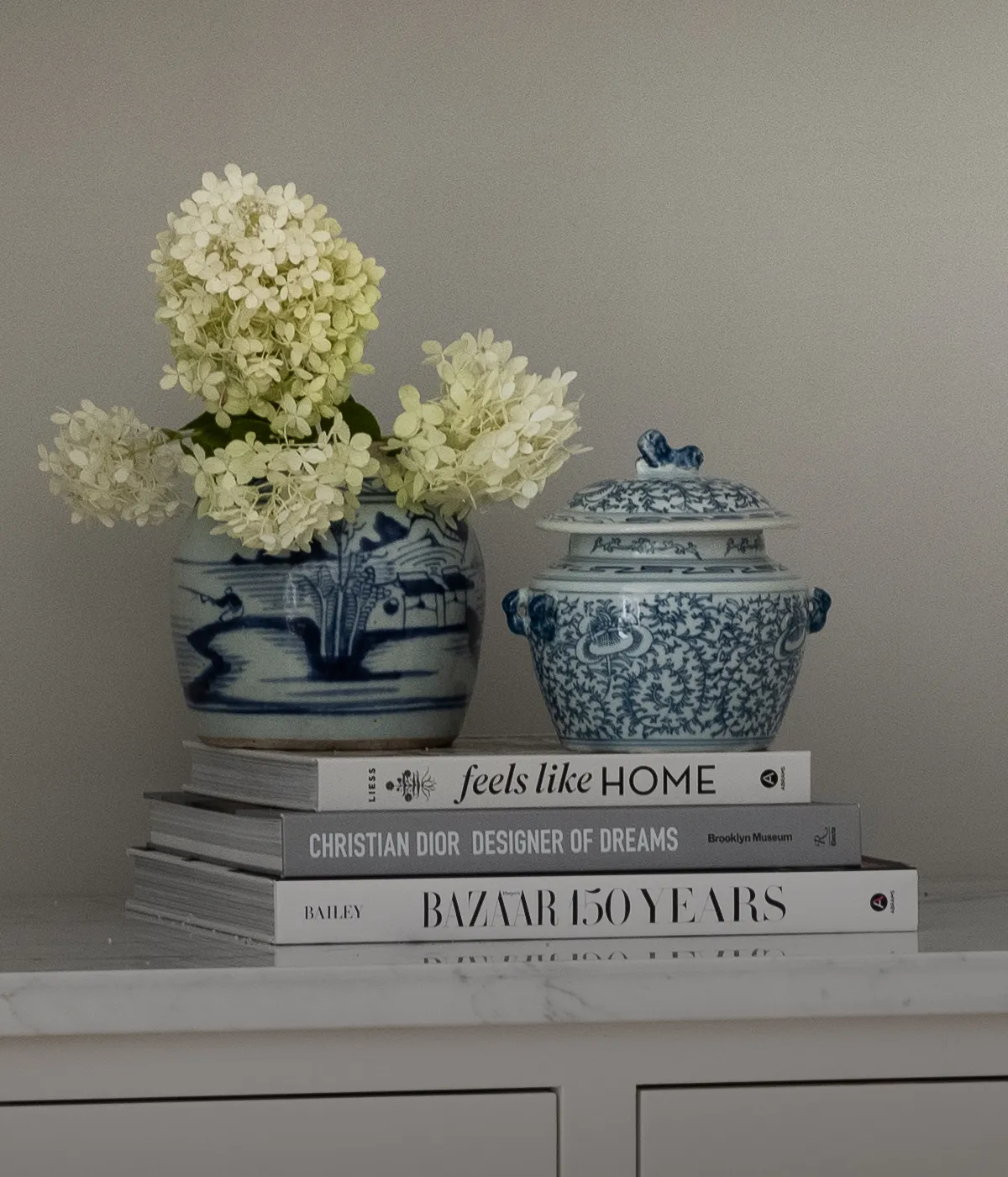 Ginger jars on a stack of fashion books, including Christian Dior.